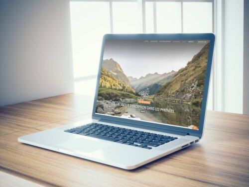 Ordinateur portable posé sur une table présentant le site internet de l'hôtel restaurant Chez Pierre d'Agos