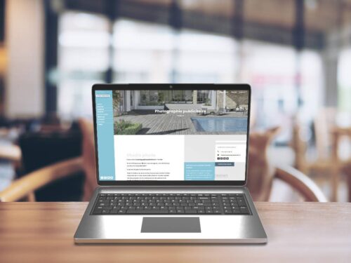 Création de site internet de photographe présentée dans un écran d'ordinateur de portable posé sur un bureau
