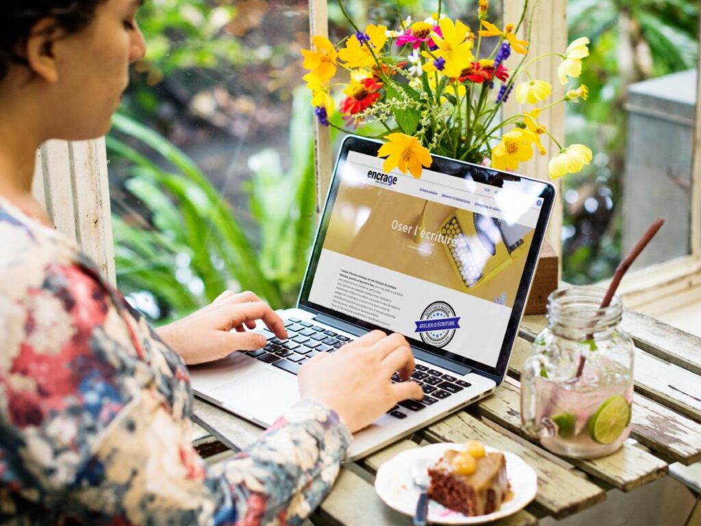 Création de site internet en Vendée, Atelier Encrage, femme assise devant un écran