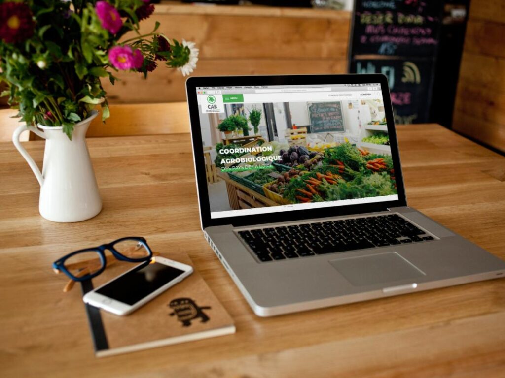 Ordinateur portable posé sur un bureau présentant la page d'accueil du CAB, création de site internet à Nantes