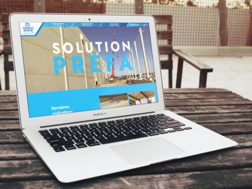 Création de site internet en Vendée, site catalogue Maison Bleue La Roche-sur-Yon, ordinateur posé sur une table présentant le site internet