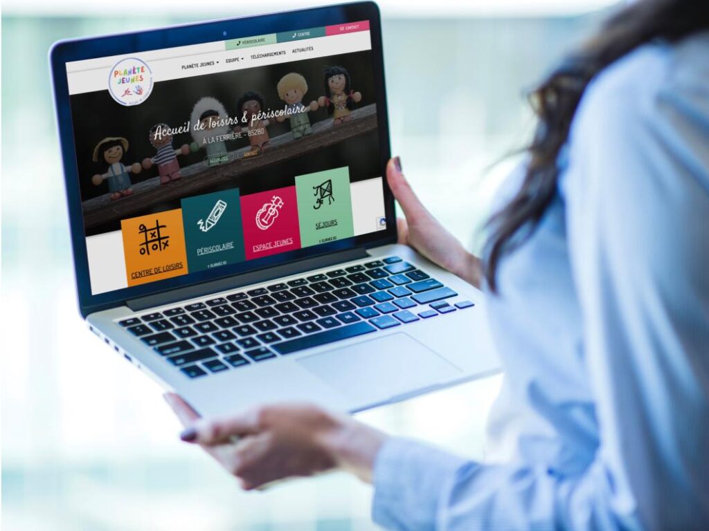 Création de site internet à La Roche-sur-Yon, Planète jeunes, femme tenant un ordinateur avec la page d'accueil du site internet