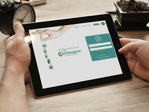 Mains d'homme tenant une tablette affichant la création de boutique en ligne de Votre conciergerie